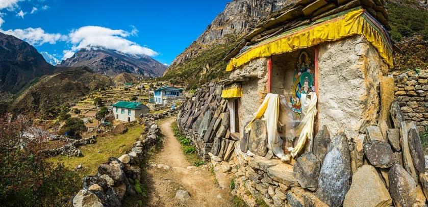 Buddhist shrine and Mani Stones carved with mantras beside an earth trail through a Sherpa village in the remote Thame valley of the Everest National Park of the Khumbu Himalaya mountains Nepal